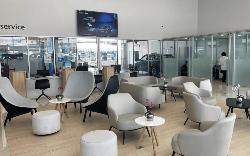 Proton eMAS showroom featuring electric car models and customer lounge area
