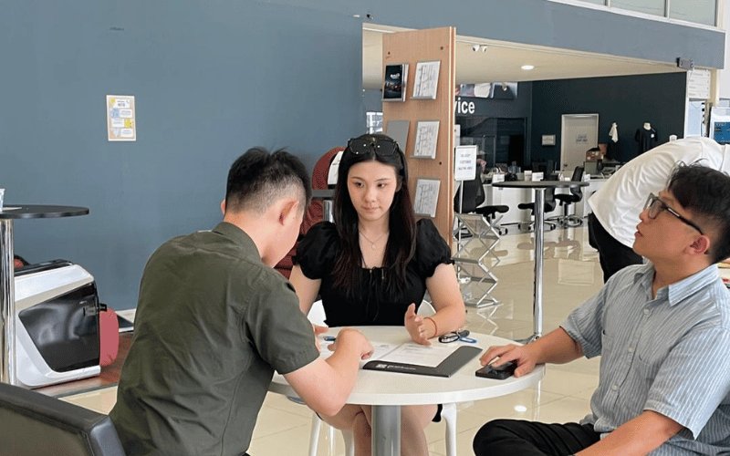Proton eMAS showroom staff assisting customer with EV details at consultation