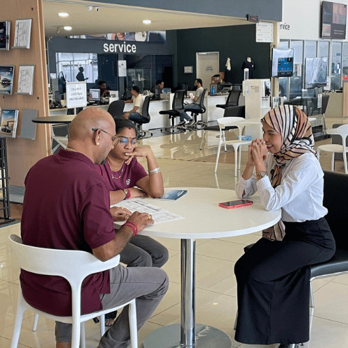 Customer discussing ev car options with sales advisor inside Proton eMAS showroom in kuala lumpur